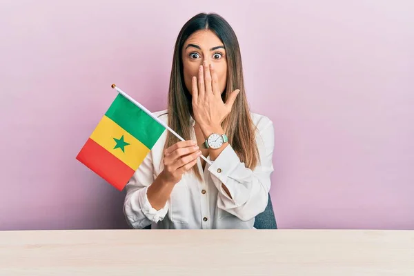 Jovem Hispânica Segurando Bandeira Senegal Sentada Mesa Cobrindo Boca Com — Fotografia de Stock