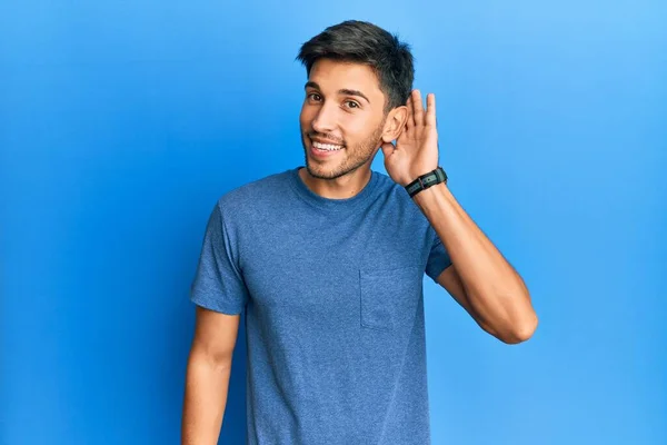 Joven Hombre Guapo Con Camiseta Casual Sobre Fondo Azul Sonriendo —  Fotos de Stock