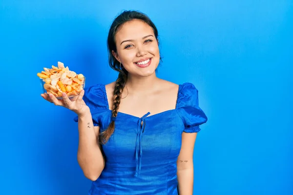 Молодая Латиноамериканка Миской Картофельного Чипса Выглядит Позитивно Счастливо Стоя Улыбаясь — стоковое фото