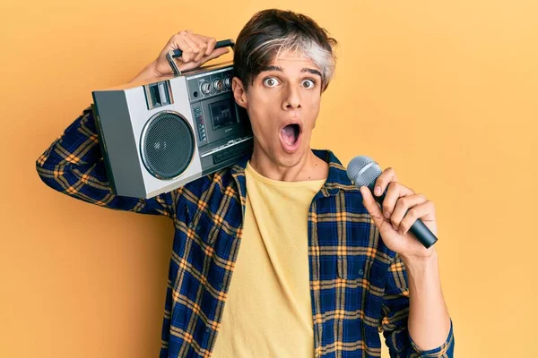 Young Hispanic Man Singing Song Using Microphone Boombox Afraid Shocked — Stock Photo, Image