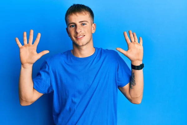 年轻的高加索人穿着休闲的蓝色T恤 用十号手指指尖 面带微笑 自信而快乐 — 图库照片