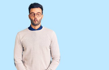 Zarif kıyafetler ve gözlük takan genç yakışıklı İspanyol adam dudaklarıyla balık suratı yapıyor, çılgınca ve komik bir jest. Komik ifade. 