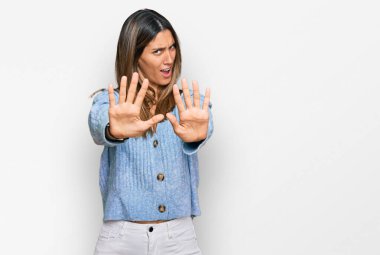 Rahat kıyafetler giyen genç bir kadın avuç içi hareketlerini durduruyor, kızgın ve hayal kırıklığına uğramış bir ifade takınıyor. 