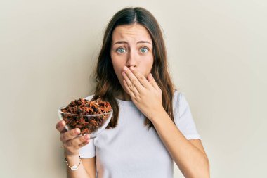 Genç esmer kadın elinde bir kase yıldız anason tutuyordu. Ağzını eliyle kapatıyordu. Şok olmuştu ve hata yapmaktan korkuyordu. şaşırmış ifade 