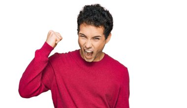 Genç, yakışıklı bir adam, kızgın ve kızgın. Öfkeyle bağırırken yumruğunu sallıyor ve öfkeleniyor. öfke ve agresif konsept. 