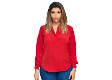 Yüzünde ciddi bir ifade olan günlük kıyafetler giyen güzel esmer kadın. Basit ve doğal bir şekilde kameraya bakıyorsun.. 