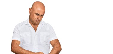 Bıyıklı, normal beyaz gömlekli olgun bir orta doğulu saati kontrol ediyor, rahat ve kendinden emin. 