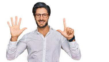 Young hispanic man wearing business shirt and glasses showing and pointing up with fingers number seven while smiling confident and happy. 