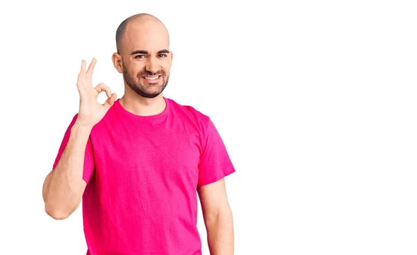 若いハンサムな男は 手と指でOkサインを行う積極的な笑顔のカジュアルTシャツを着ている 成功した表現 — ストック写真