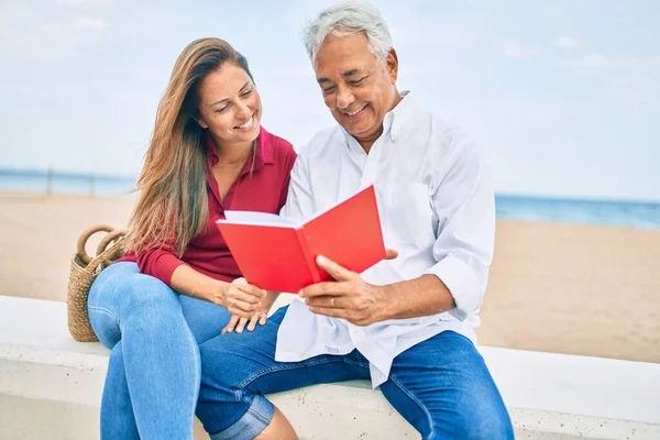 Middelbare Leeftijd Spaanse Echtpaar Lezen Boek Zittend Bank Aan Het — Stockfoto