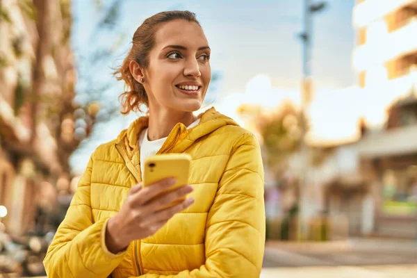 若いですヒスパニック系の女の子笑顔幸せな使用してスマートフォンで市 — ストック写真