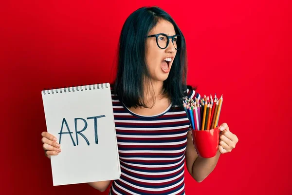 美しいアジアの若い女性のアートノートを保持し 色の鉛筆怒っていると怒っている叫び不満と激怒し 怒りで叫んでいる 怒りと攻撃的な考え方 — ストック写真