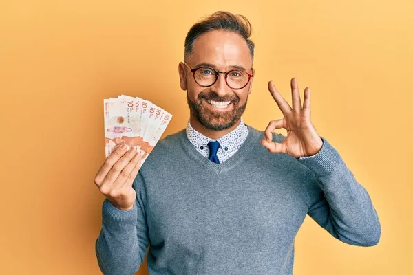 ハンサムな中年男性保持10 Colombianペソ紙幣を行うOk Signとともに指 笑顔優しいジェスチャー優れたシンボル — ストック写真