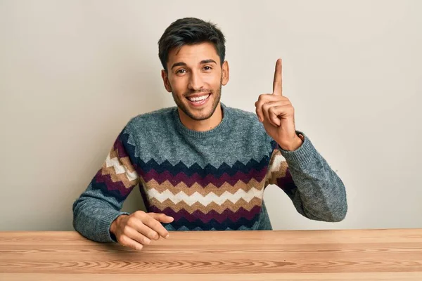 Homem Bonito Jovem Vestindo Camisola Casual Sentado Mesa Apontando Dedo — Fotografia de Stock