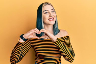 Sıradan çizgili tişört giyen, aşık bir genç modern kız elleriyle kalp sembolü çiziyor. romantik kavram. 