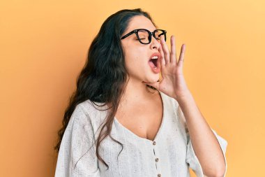 Güzel bir ortadoğulu kadın gündelik kıyafetler ve gözlük takıp el ele tutuşarak bağırıyor ve çığlık çığlığa bağırıyordu. iletişim konsepti. 