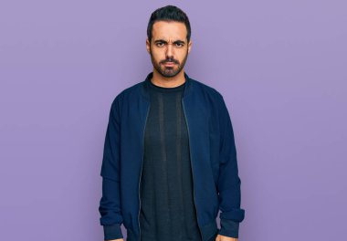 Gündelik kıyafetler giyen, kuşkucu ve gergin genç İspanyol bir adam sorun yüzünden surat asıyor. negatif kişi. 