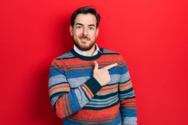 Sakallı, zarif, yünlü, kış süveteri giyen yakışıklı beyaz bir adam. Yüzünde mutlu ve doğal bir ifadeyle, elleri ve parmaklarıyla yüzünü gösteren bir tebessüm. 