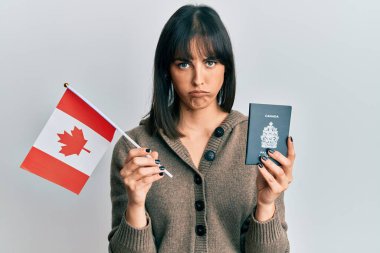 Elinde Kanada bayrağı ve pasaport taşıyan genç İspanyol kadın şüpheci ve gergin, sorun yüzünden surat asıyor. negatif kişi. 