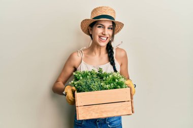 Genç İspanyol kadın elinde yeşil saksı tutarak çılgınlığı kutluyor ve başarıya hayret ediyor gözleri açık heyecanla haykırıyor. 