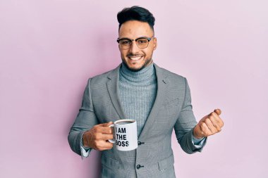 Genç Arap adam ben patron kahve fincanından içerken gururla haykırıyor, zaferi kutluyor ve başarıyı kollarını kaldırarak kutluyor. 