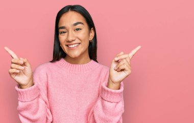 Kış süveteri giyen genç Asyalı kadın farklı yönleri gösteren kendine güvenle gülümsüyor. reklam için kopyalama alanı 