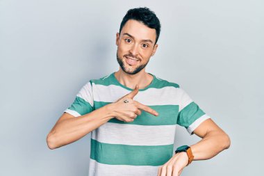 Gündelik giysiler giyen genç İspanyol adam saati, sabırsızlığı ve gecikmeyi izlemek için acele ediyor. 