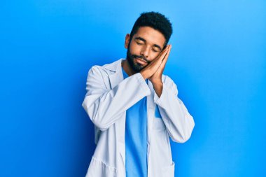 Yakışıklı, sakallı, doktor üniforması giyen, yorgun uyuyan, hayal kuran ve elleriyle poz veren, gözleri kapalı bir İspanyol.. 