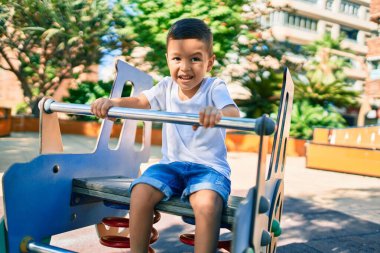 Sevimli İspanyol çocuk gülümsüyor. Parkta oynayarak mutlu oluyor..