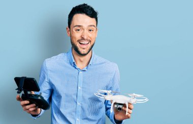 Uzaktan kumandalı İHA kullanan sakallı İspanyol adam gülüyor ve kahkahalar atıyor.. 