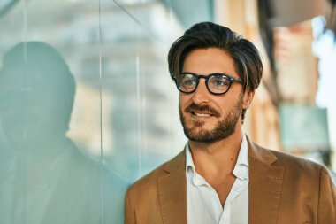 Genç İspanyol işadamı gülümseyerek şehirde mutlu mesut duruyor..