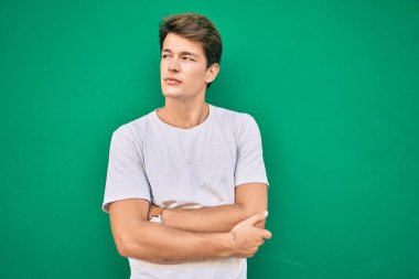 Şehrin duvarına yaslanmış, ciddi bir suratı olan beyaz bir genç..