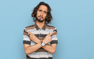 Gündelik kıyafetler giyen genç İspanyol adam her iki tarafı da parmaklarıyla işaret ediyor, farklı yönlerde farklı görüşler. 