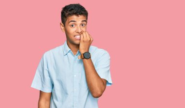 Genç, yakışıklı, Afro-Amerikan bir adam. Günlük kıyafetler giyiyor. Stresli ve gergin görünüyor. anksiyete. 