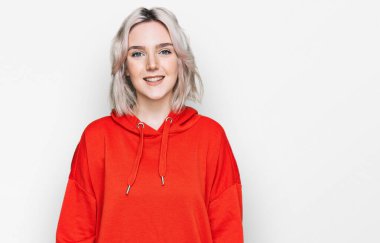 Mutlu ve havalı bir gülüşü olan sıradan kıyafetler giyen genç sarışın kız. şanslı kişi. 