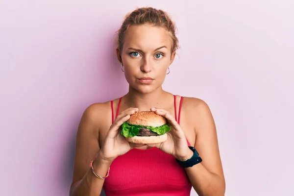 Schöne Kaukasische Frau Isst Einen Leckeren Klassischen Burger Skeptisch Und — Stockfoto