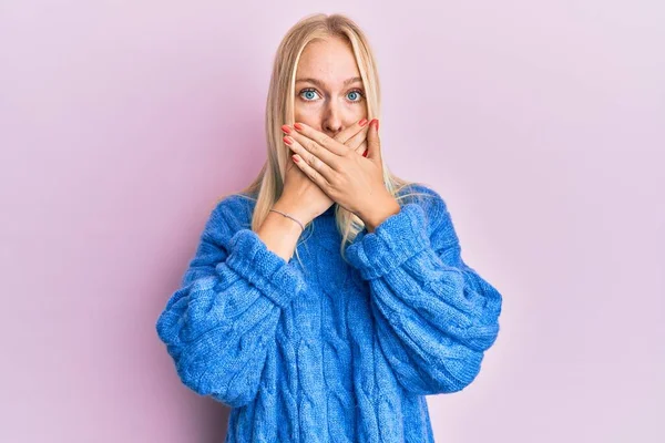 Młoda Blondynka Nosząca Wełniany Zimowy Sweter Zszokowana Zakrywaniem Ust Dłońmi — Zdjęcie stockowe