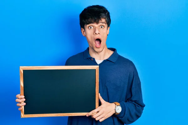 Handsome Hipster Young Man Holding Blackboard Afraid Shocked Surprise Amazed — Stock Photo, Image