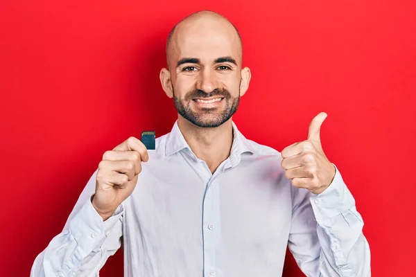 Young Bald Man Holding Sdxc Card Smiling Happy Positive Thumb — Stock Photo, Image