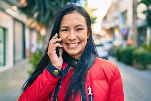 若いラテン語の女性の笑顔幸せな話上のスマートフォンで街 — ストック写真