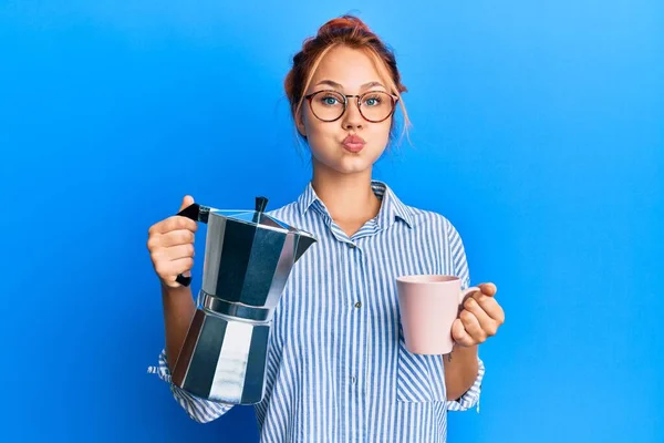 Joven Pelirroja Bebiendo Café Italiano Soplando Mejillas Con Cara Divertida —  Fotos de Stock