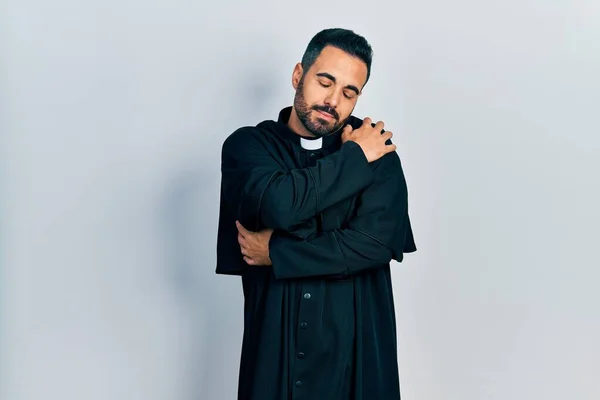 Handsome Hispanic Man Beard Wearing Catholic Priest Robe Hugging Oneself — Φωτογραφία Αρχείου