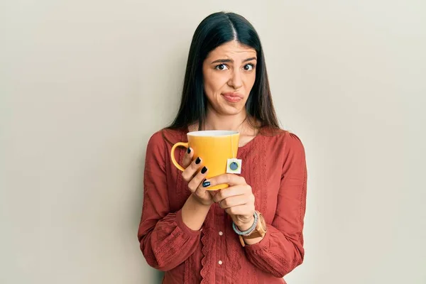 Молода Іспаномовна Жінка Тримає Чашку Чаю Скептично Нервово Розчаровуючись Через — стокове фото