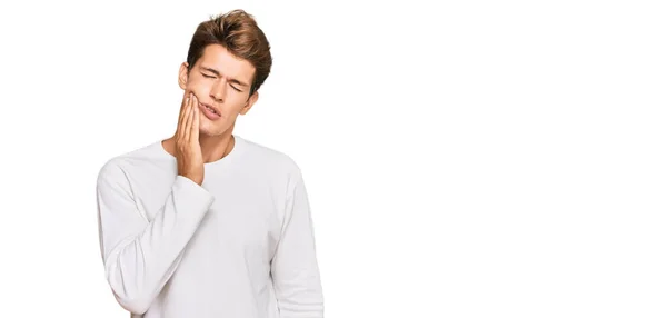 英俊的白人男子 身穿宽松的白色毛衣 手牵着嘴 因牙痛或牙齿疾病而有痛苦的表情 — 图库照片