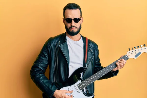 Jovem Com Barba Tocando Guitarra Elétrica Cético Nervoso Franzindo Testa — Fotografia de Stock