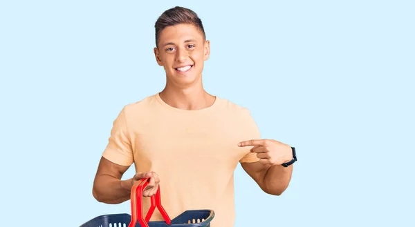 Joven Hombre Hispano Guapo Sosteniendo Cesta Compra Del Supermercado Señalando — Foto de Stock