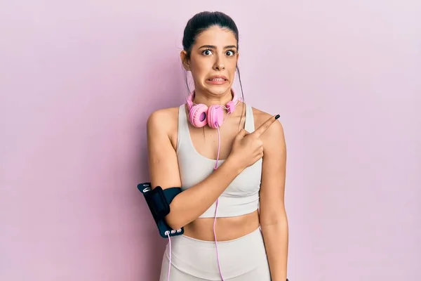 Mujer Hispana Joven Vestida Con Ropa Gimnasia Usando Auriculares Apuntando — Foto de Stock