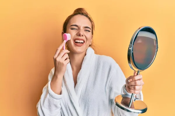 Mujer Rubia Joven Con Bata Sosteniendo Cepillo Removedor Maquillaje Celebrando — Foto de Stock