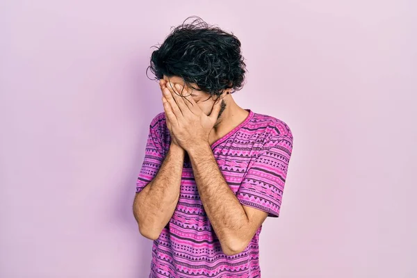 泣きながら手で顔を覆う悲しい表情のカジュアルなピンクのTシャツを着たハンサムなヒスパニック系の男 うつ病の概念 — ストック写真