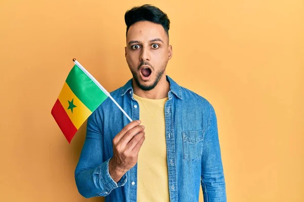 Hombre Árabe Joven Sosteniendo Bandera Senegal Asustado Sorprendido Con Boca —  Fotos de Stock